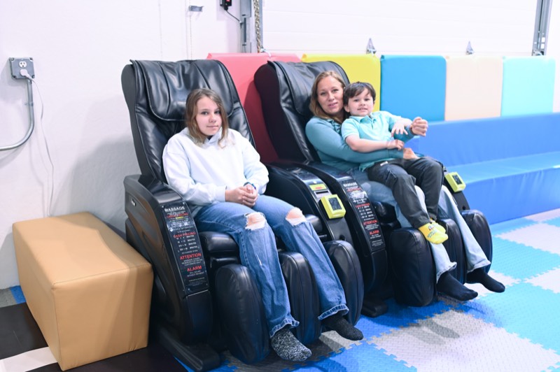 Grown-ups relaxing in the massage chairs while the kids play