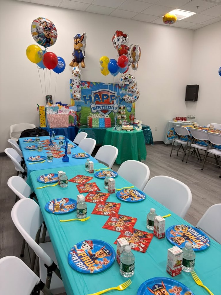 Paw Patrol party in blue: character balloons, teal tablecloth and themed plates down a long table