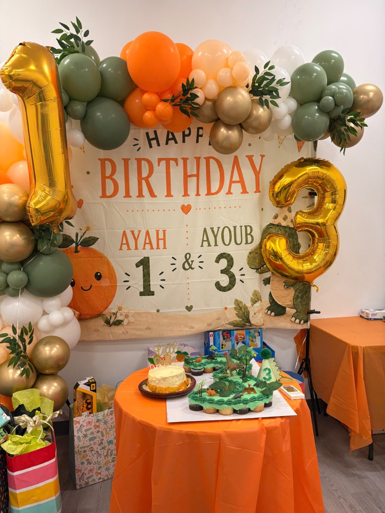 Safari and citrus themed party for twins with sage and orange balloon garland and gold number balloons
