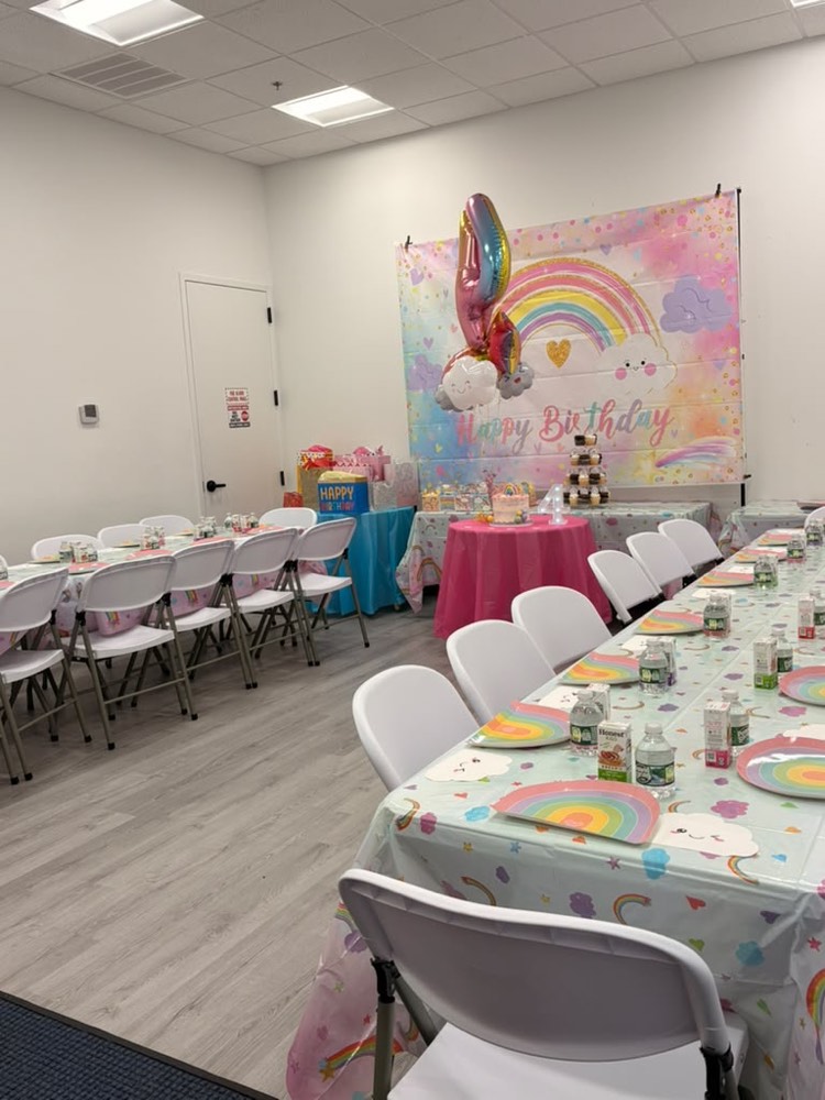 Rainbow and unicorn party: pastel rainbow backdrop, cupcake tower and pastel table settings